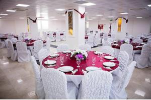 un salón de banquetes con mesas blancas y sillas blancas en GÜNTURPARK OTEL en Beylerbeyi
