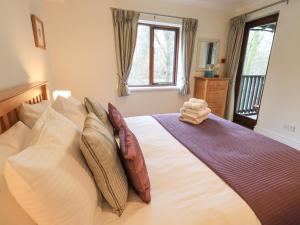 a bedroom with a large white bed with pillows at Beechside in Ambleside