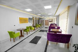 - une salle d'attente avec des tables et des chaises pourpres et vertes dans l'établissement GÜNTURPARK OTEL, à Beylerbeyi
