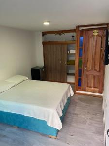 um quarto com uma cama e uma porta de madeira em Habitación La Amelia em Jericó