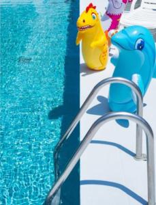 una piscina con giocattolo giallo e blu accanto a una piscina di Grand Meeting Hotel a Rimini