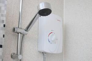 a shower head on a wall in a bathroom at Big Value Bedsit by Property Promise in Cardiff