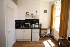 a small kitchen with a counter and a microwave at Big Value Bedsit by Property Promise in Cardiff