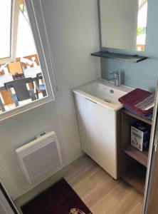 a bathroom with a sink and a window at A la brise du Ferret in Lège-Cap-Ferret