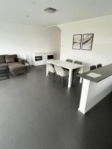 ein Wohnzimmer mit einem Tisch, Stühlen und einem Sofa in der Unterkunft Luxuswohnung direkt am Phönixsee in Dortmund