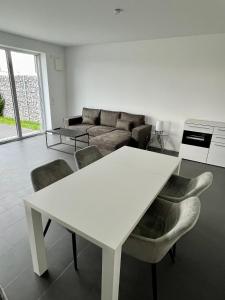 ein Wohnzimmer mit einem weißen Tisch und Stühlen in der Unterkunft Luxuswohnung direkt am Phönixsee in Dortmund
