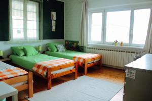 um quarto com duas camas, um sofá e janelas em Apartment Hiža 38 em Mala Subotica