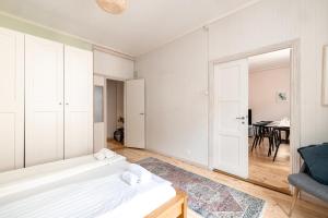 een slaapkamer met 2 witte bedden en een tafel bij 2ndhomes Bright 125m2 4BR City Center Apartment with the Great Views in Helsinki