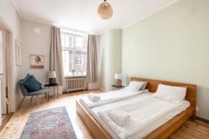 een slaapkamer met een groot bed met witte lakens bij 2ndhomes Bright 125m2 4BR City Center Apartment with the Great Views in Helsinki