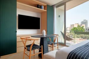 a bedroom with a table and chairs and a tv at Casa Cibeles by Lumina in Mexico City