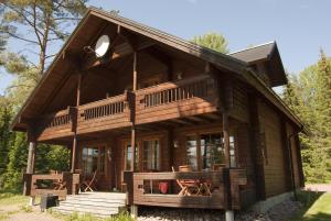 a log cabin with a porch and a deck at Ekströms Stugor in Gottby