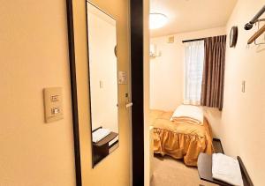 una stanza con specchio e letto in esso di Hotel MitsuWakan - Vacation STAY 15763v a Tsushima