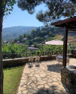 two birds sitting on a patio with an umbrella at ŞİRİNCE BAHÇE OTEL in Selcuk