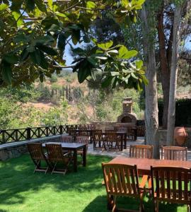 a group of wooden tables and chairs in a park at Adissa Butik Otel in Selçuk +31 photos