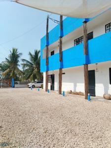 Hotel Palmetto Beach Coveñas في كوفيناس: مبنى على الشاطئ مع حواجز زرقاء في الأمام