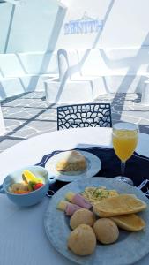 uma mesa com dois pratos de comida e um copo de sumo de laranja em Zenith em Arraial do Cabo