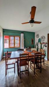 Un comedor con mesa y sillas y un ventilador de techo. en Apartamento Inteiro – Conforto e paz, en Ilhabela
