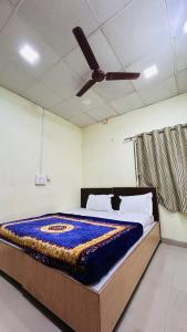 a bedroom with a bed with a ceiling fan at Aashapurti Hotel in Aurangabad