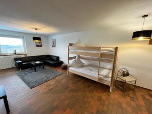 een woonkamer met een stapelbed en een bank bij Premium Apartment 70qm 2,5 Zimmer Küche, Smart TV, Garage, WiFi in Heidenheim an der Brenz