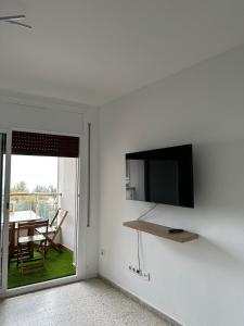 een woonkamer met een flatscreen-tv aan de muur bij Vista al mar in Roses