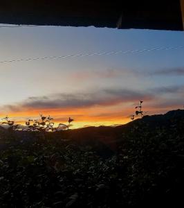 Blick auf den Sonnenuntergang von der Spitze eines Berges in der Unterkunft Hostal el Vaquero in Chugchilán