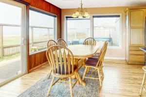 - une salle à manger avec une table, des chaises et des fenêtres dans l'établissement Sparkling Sands Oceanfront, à San Marine
