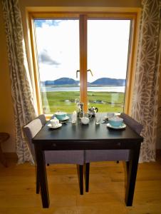 a dining room table with a view of a window at Rysa House B&B in Stromness