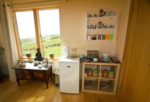 a kitchen with a white refrigerator and a table at Rysa House B&B in Stromness