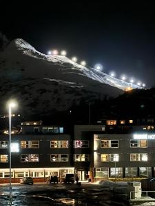 un edificio con una montaña en el fondo por la noche en 3-roms leilighet, Svolvær, Lofoten, en Svolvær