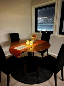 mesa de comedor con sillas y ventana grande en 3-roms leilighet, Svolvær, Lofoten, en Svolvær