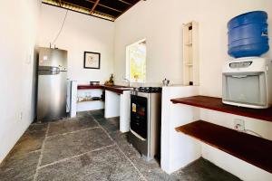 a kitchen with a refrigerator and a stove top oven at La Casita Atins in Atins
