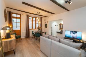 a living room with a couch and a tv at Appartement typique hyper centre Albi - Neuf Premium - Parking gratuit in Albi +19 photos