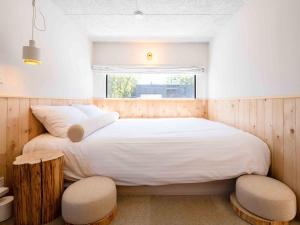 1 Schlafzimmer mit einem großen Bett und 2 Stühlen in der Unterkunft Ashigarashimogun - Glamping - Vacation STAY 75747v in Sengokuhara
