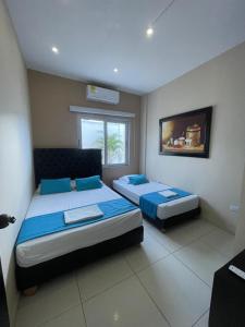 a bedroom with two beds and a window at Cabanas Villa Antonella Covenas in Coveñas +78 photos
