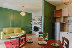 ein grünes Wohnzimmer mit einem Tisch und einem Sofa in der Unterkunft Countryside Apartment in Tushemisht