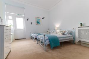 a bedroom with two beds in a white room at The Spires in Scarborough