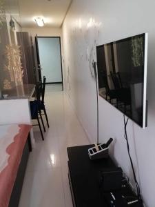 a living room with a couch and a tv on a wall at Birchtower studio in Manila