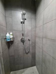 een douchecabine met een douchekop in de badkamer bij KaMi Homestay (2-3pax)/国际机场5分钟 in Donggongon