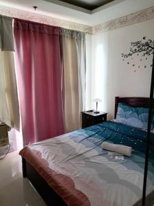 a bedroom with a large bed with a red curtain at Birchtower studio in Manila