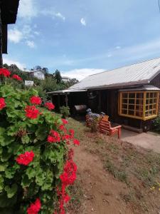 una casa con flores rojas delante de ella en Cabañas Arrayán en Ancud