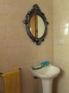 baño con lavabo y espejo en la pared en Cabañas Arrayán, en Ancud