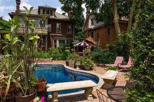 un patio trasero con piscina y una casa en Mike & Allen's Place on the Park_2 en Columbus