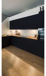 a kitchen with black cabinets and a wooden counter top at ApartmentInCopenhagen Apartment 1595 in Copenhagen
