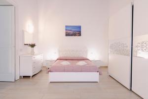 een witte slaapkamer met een bed en een spiegel bij Gli Appartamenti della Villa in Santa Maria Capua Vetere