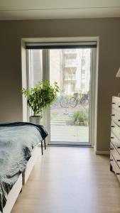 - une chambre avec un lit et une grande porte coulissante en verre dans l'établissement ApartmentInCopenhagen Apartment 1595, à Copenhague