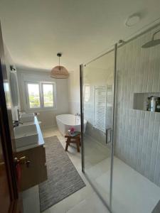 un bagno con doccia, vasca e lavandino di Villa Mercedes a Tebra