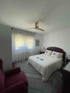 una camera da letto con un letto e un ventilatore a soffitto di Villa Mercedes a Tebra