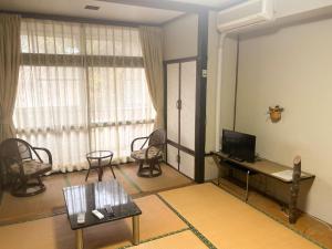 a living room with a tv and a table and chairs at Eco Hotel Yunokosou - Vacation STAY 99606v in Minamata