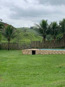 una pared de piedra en medio de un campo con palmeras en Fazenda Cachoeira - Rialto, en Barra Mansa