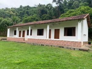 una casa con un campo de hierba delante de ella en Fazenda Cachoeira - Rialto, en Barra Mansa